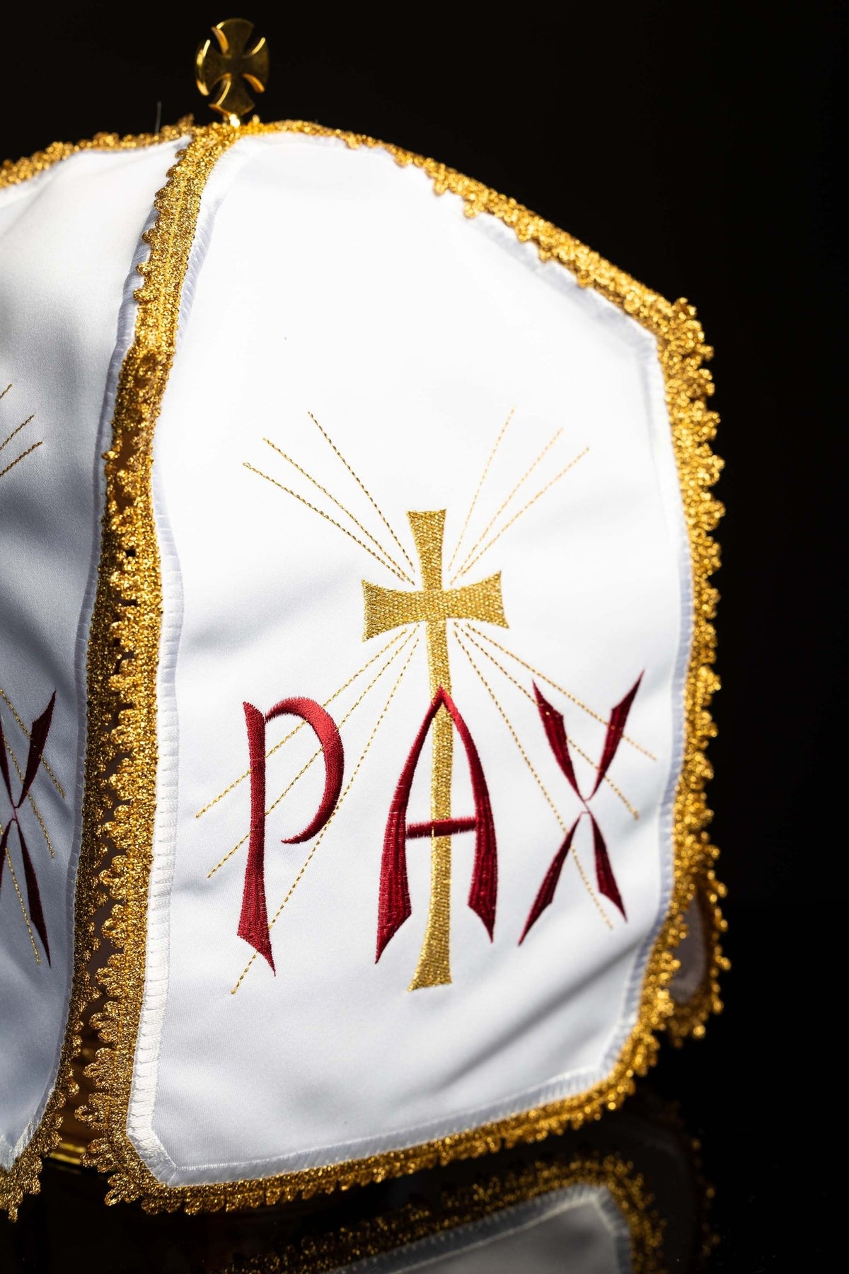 Welon na puszkę Pax – zbliżenie białego przodu ze złotym krzyżem i ozdobną lamówką