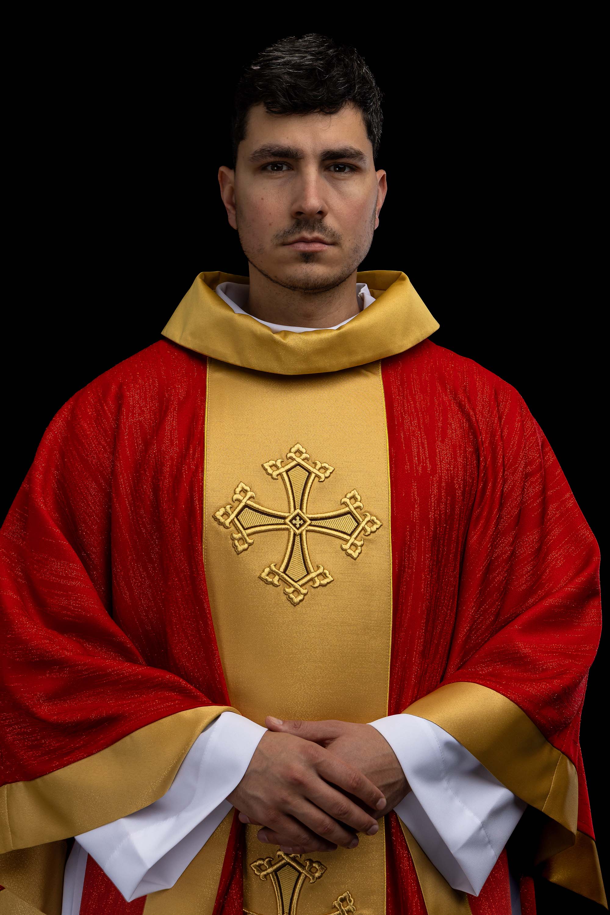 Czerwony ornat z haftowanym motywem krzyża z pasem na ozdobnej tkaninie